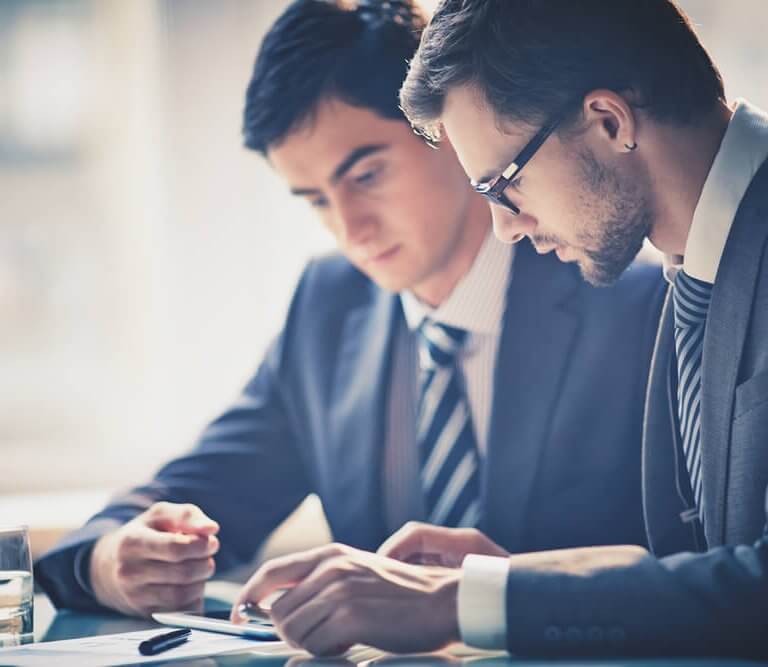 Two business men at table looking at document